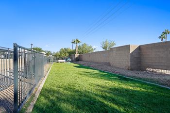 a fenced in yard with grass next to a fence